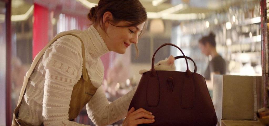 Jeune fille avec un sac Longchamp duquel sort la tête d'un chaton