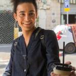 Personne transgenre souriante prenant un café