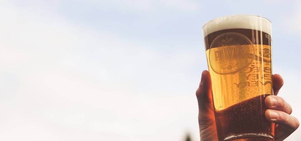 Personne qui lève son verre de bière