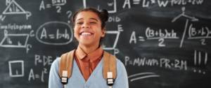 Jeune fille souriante devant un tableau d'école
