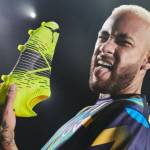 Neymar Jr. avec une basket jaune fluo dans la main et tirant la langue