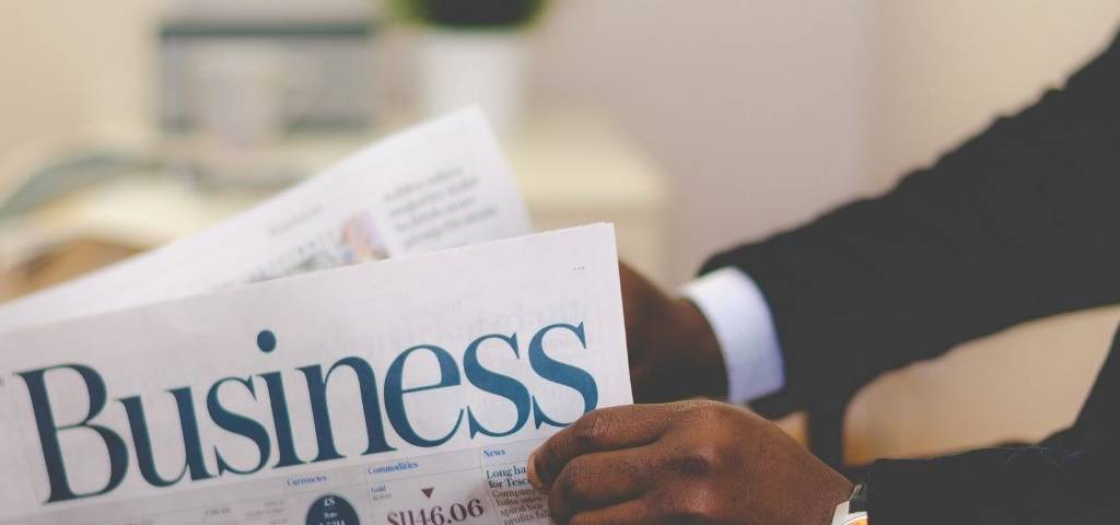 Jeune homme lisant un journal business
