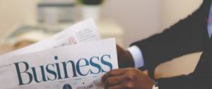 Jeune homme lisant un journal business