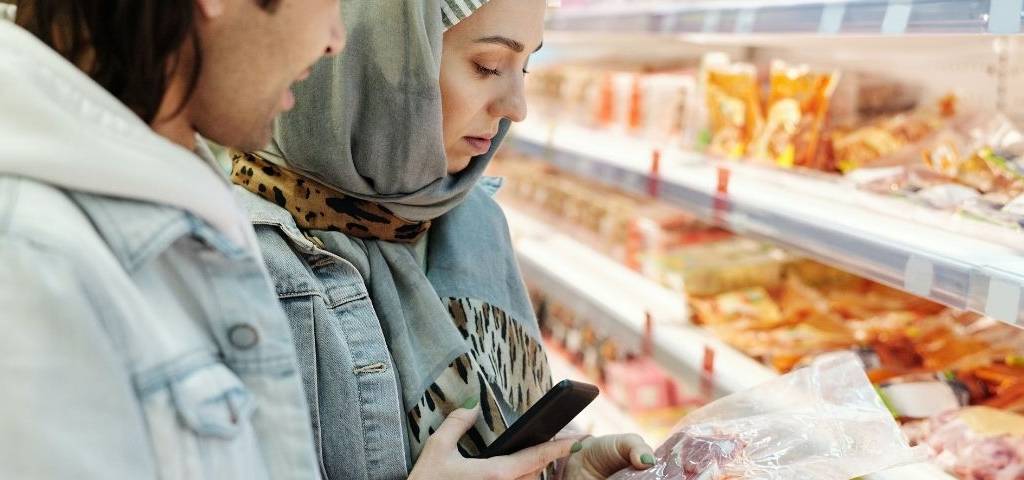 Couple regardant une étiquette dans un supermarché