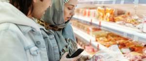 Couple regardant une étiquette dans un supermarché