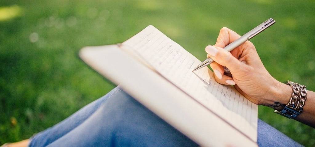 Imaginée et conçue par deux professionnels du livre, Édith & Nous est une plateforme de mise en relations pour les auteurs et les éditeurs jeune femme écrivant sur un cahier