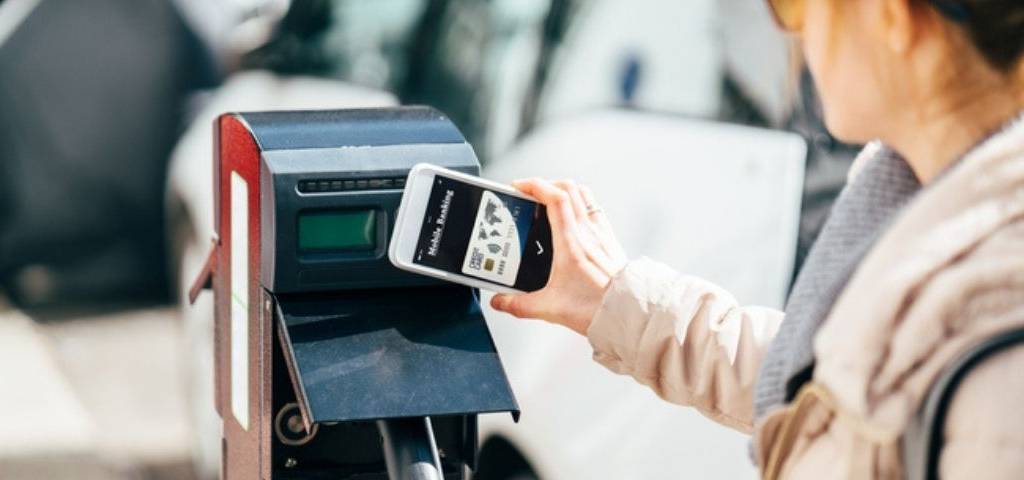 Une femme recharge sa voiture électrique