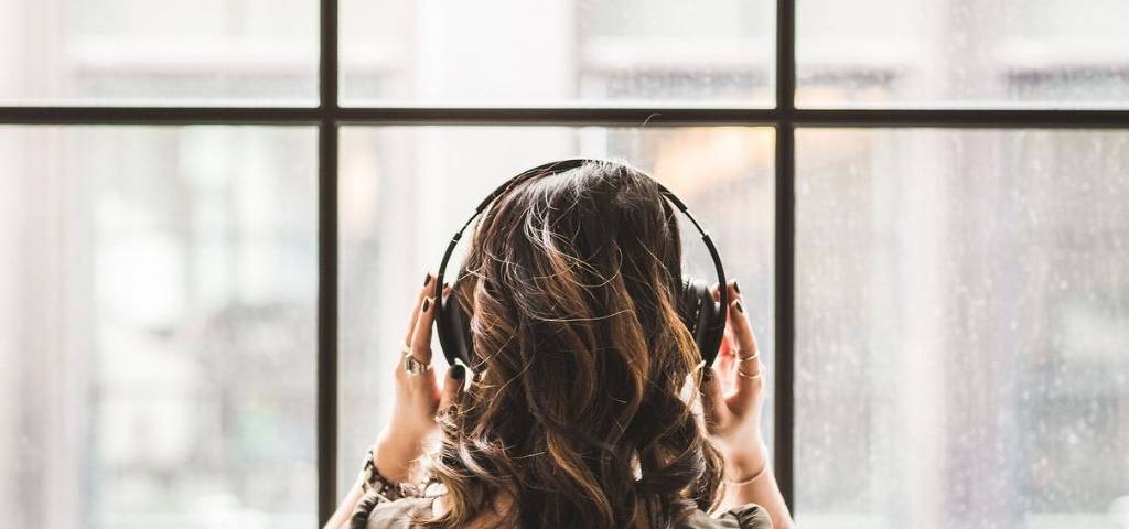 Femme de dos avec un casque sur les oreilles