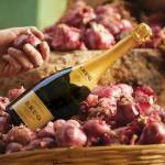 Bouteille de champagne, posée sur un panier avec des oignons