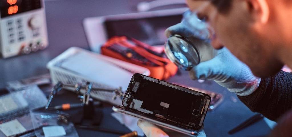 Un homme répare un smartphone