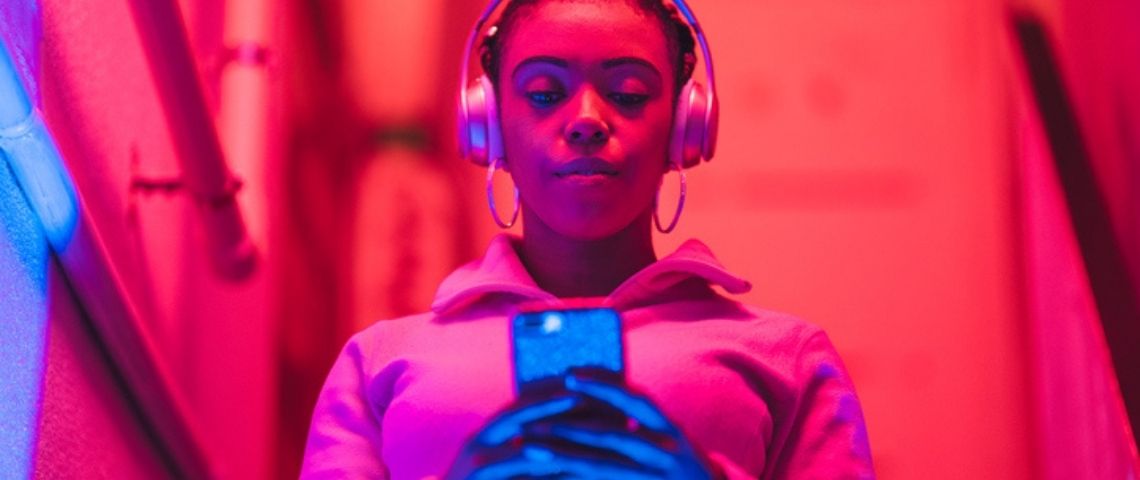 Comment mettre en place une stratégie de marketing digital efficace ? Une femme sur son tel avec des lumières rouges