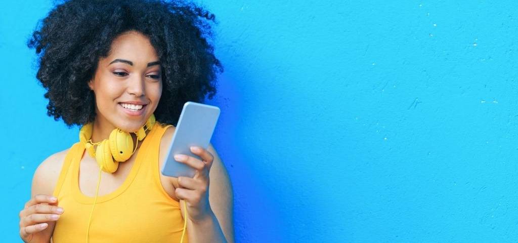 Les nouvelles pratiques social ads en 2021 : comment éviter une hausse des coûts ?  Une femme avec un téléphone dans les mains