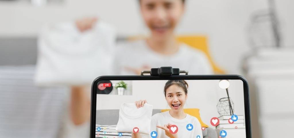 L’agence Heaven propose une nouvelle offre : le Live Shopping, du téléachat 2.0… ou presque Jeune fille prsentant un T-shirt à sa communauté, qui like en retour