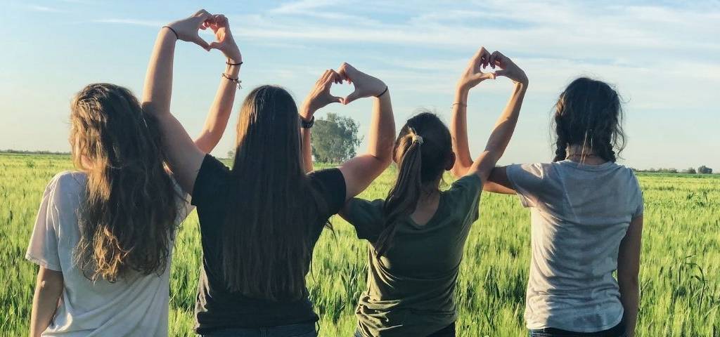 Jeunes filles de dos faisaint des coeurs avec leurs mains