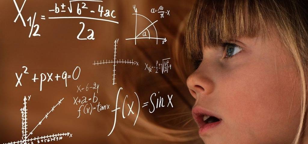 Jeune fille regardant un tableau avec des formules mathématiques