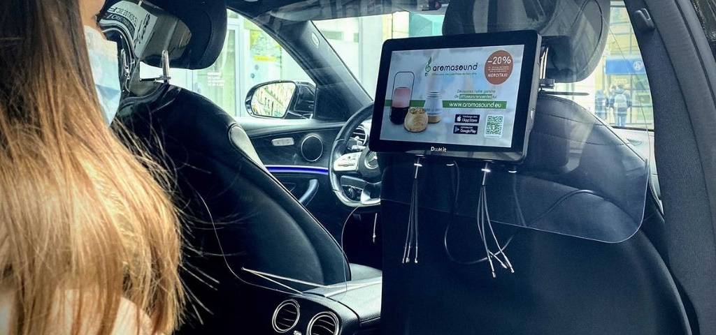 Jeune femme dans un VTC devant un écran Digicab