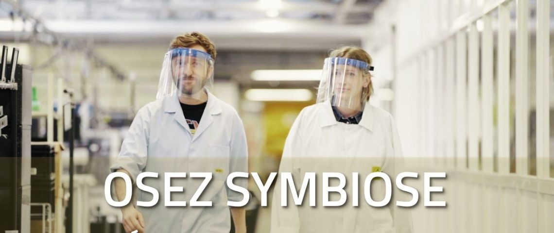 Lacroix Electronics lance une websérie inédite intitulée « Osez Symbiose, l’usine électronique du futur de Lacroix », qui présente et explique son projet de construction d’usine 4.0 qui verra le jour fin 2021. Un homme et une femme dans une usine avec une visière