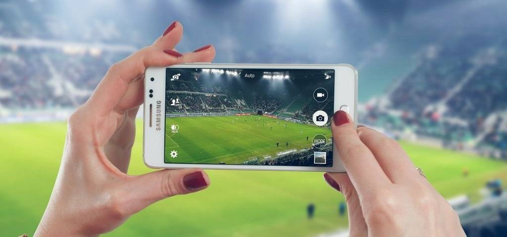 Personne filmant un match de foot avec son téléphone portable