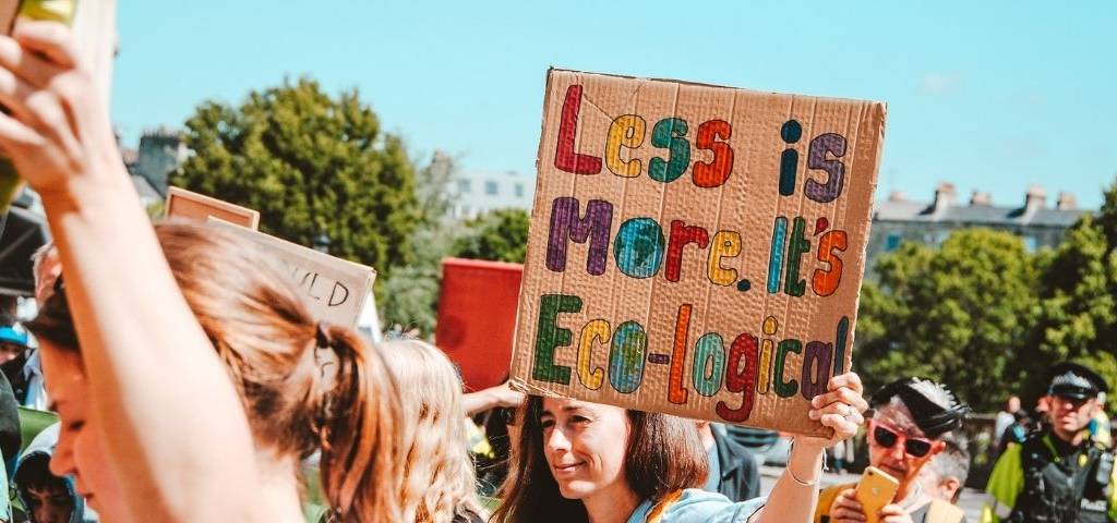 Manifestation, avec une jeune fille tenant une affiche  - Less is more, It's eco-logical - 