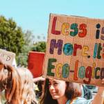 Manifestation, avec une jeune fille tenant une affiche "Less is more, It's eco-logical"