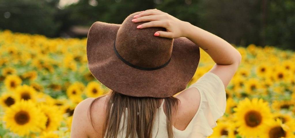 Femme de dos dans un champ de tournesol