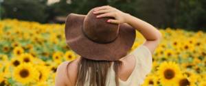 Femme de dos dans un champ de tournesol