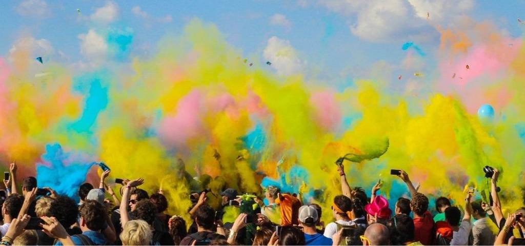 Foule à un concert avec des fumigènes colorés