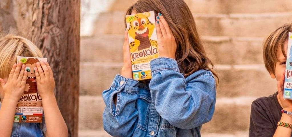 Jeunes enfants avec le visage caché par une tablette de chocolat Krokola