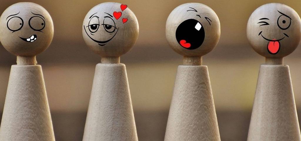 Petits personnages en bois faisant des grimaces