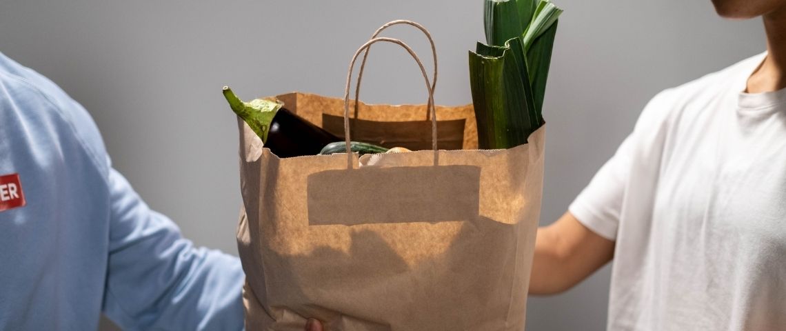 Personne donnant un sac de nourriture à une autre personne