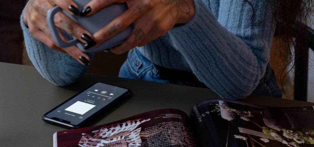 Femme écoutant un podcast une tasse à la main