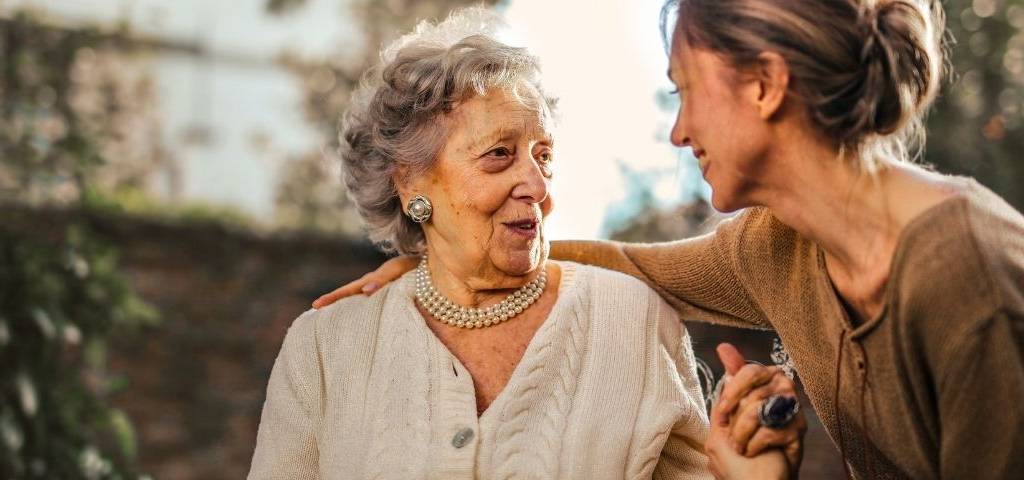 Une femme âgée et une femme adulte qui discutent avec l'air heureux
