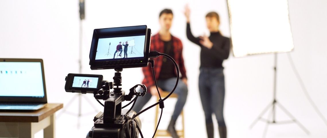 Comment déterminer le budget adéquat à allouer pour créer une vidéo corporate ?  Deux personnes en train de tourner une vidéo