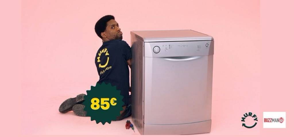 Un homme à coté d'une machine à laver sur un fond rose