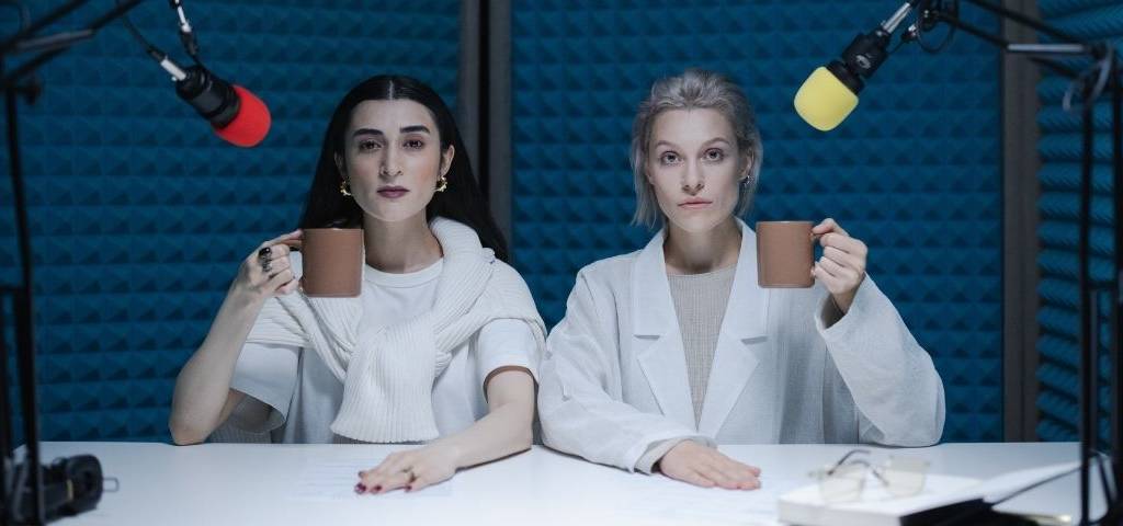 2 femmes une tasse à la main dans un studio d'enregistrement
