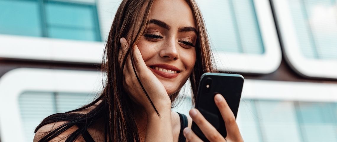 Trois conseils pour booster votre stratégie social media Une femme avec un smartphone