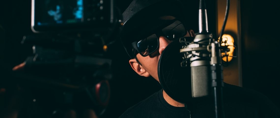 Apple investit dans UnitedMasters pour que le modèle de la distribution musicale soit davantage équitable et centrée sur l’artiste. Jeunes homme devant un micro
