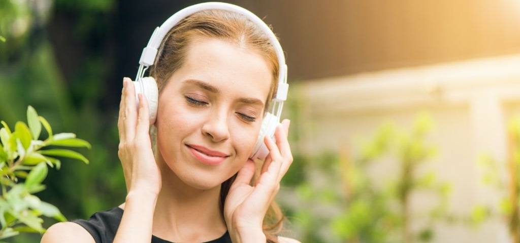 Jeune femme ayant l'air détendue avec un casque sur les oreilles