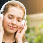 Jeune femme ayant l'air détendue avec un casque sur les oreilles