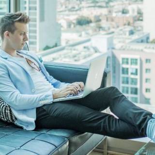 Un homme écrit sur un ordinateur