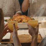 Deux enfants trinquant avec un verre de jus d'orange au restaurant