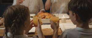 Deux enfants trinquant avec un verre de jus d'orange au restaurant