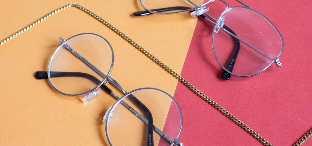 2 paires de lunettes sur fond orange et rose