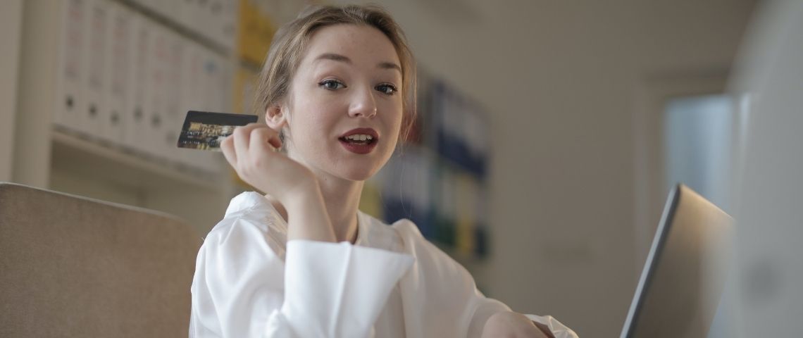 Seulement 8 mois après sa première levée de fonds, la néo-banque française séduit de nouveau les investisseurs et confirme sa pertinence auprès de toute la génération Z jeune fille devant un ordinateur avec une carte de crédit à la main