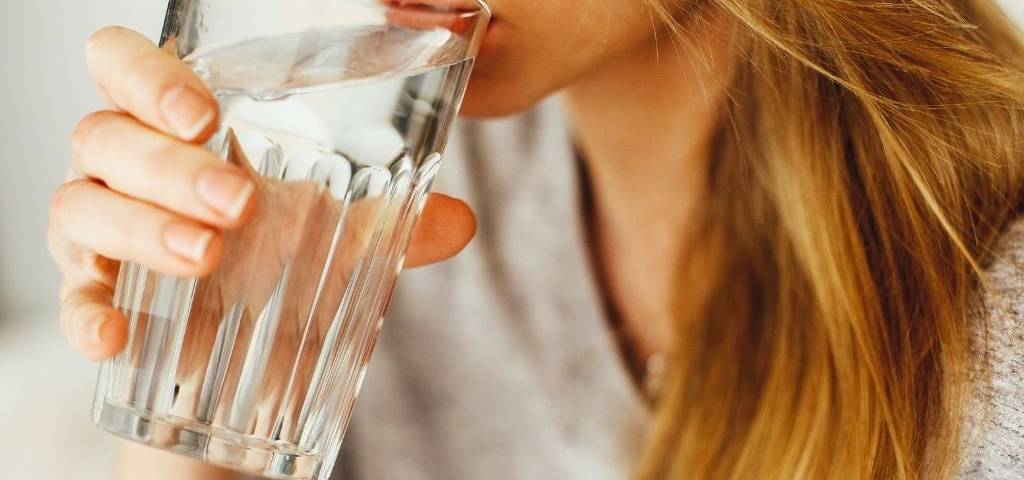 Jeune femme buvant un verre d'eau