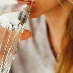 Jeune femme buvant un verre d'eau