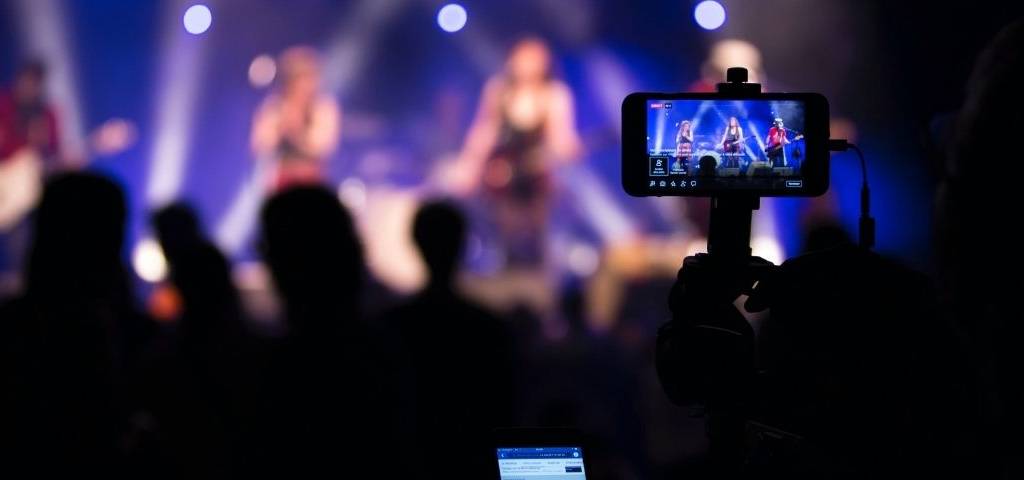 Dooweet-musique-streaming-plateforme-reseaux-sociaux-visibilité-artistes-rentabilité-fanbase Concert avec un téléphone qui filme