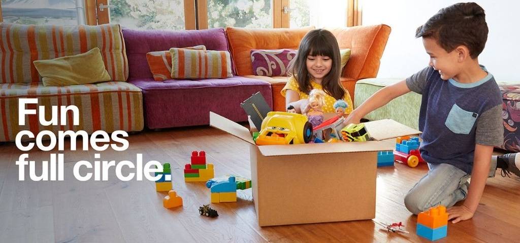 Des enfants qui mettent des jouets dans un carton