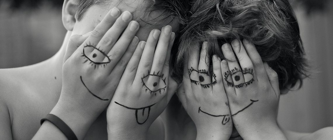 OuiGo-tourisme-voyage-train-petits-prix-campagne-communication-jeu-concours Deux enfants qui se cachent le visage avec leurs mains. Ils ont dessiné des smileys