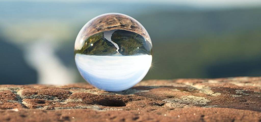 un paysage qui se reflète dans une boule en verre